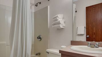 A bathroom with a shower, toilet, and sink.