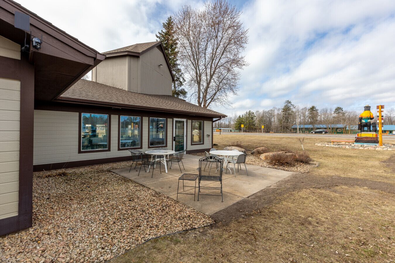 A building with a patio area, large windows, and outdoor seating.