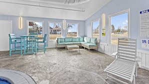 A spa area with a seating arrangement, a pool, and large windows. - Nisswa Hotel & Suites – Cullen Lake Jacuzzi King (Nisswa)
