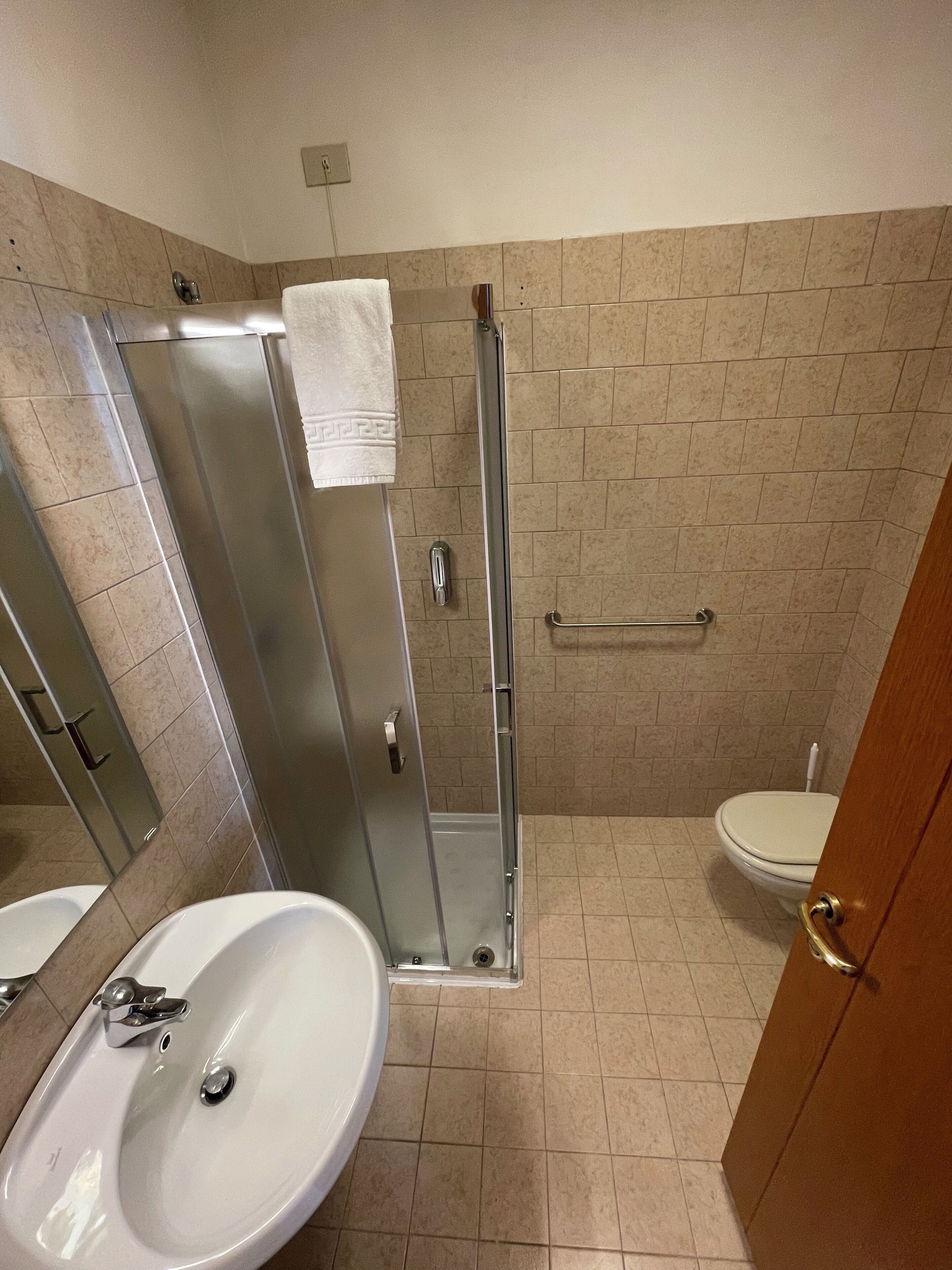 A bathroom with a shower, toilet, and sink.