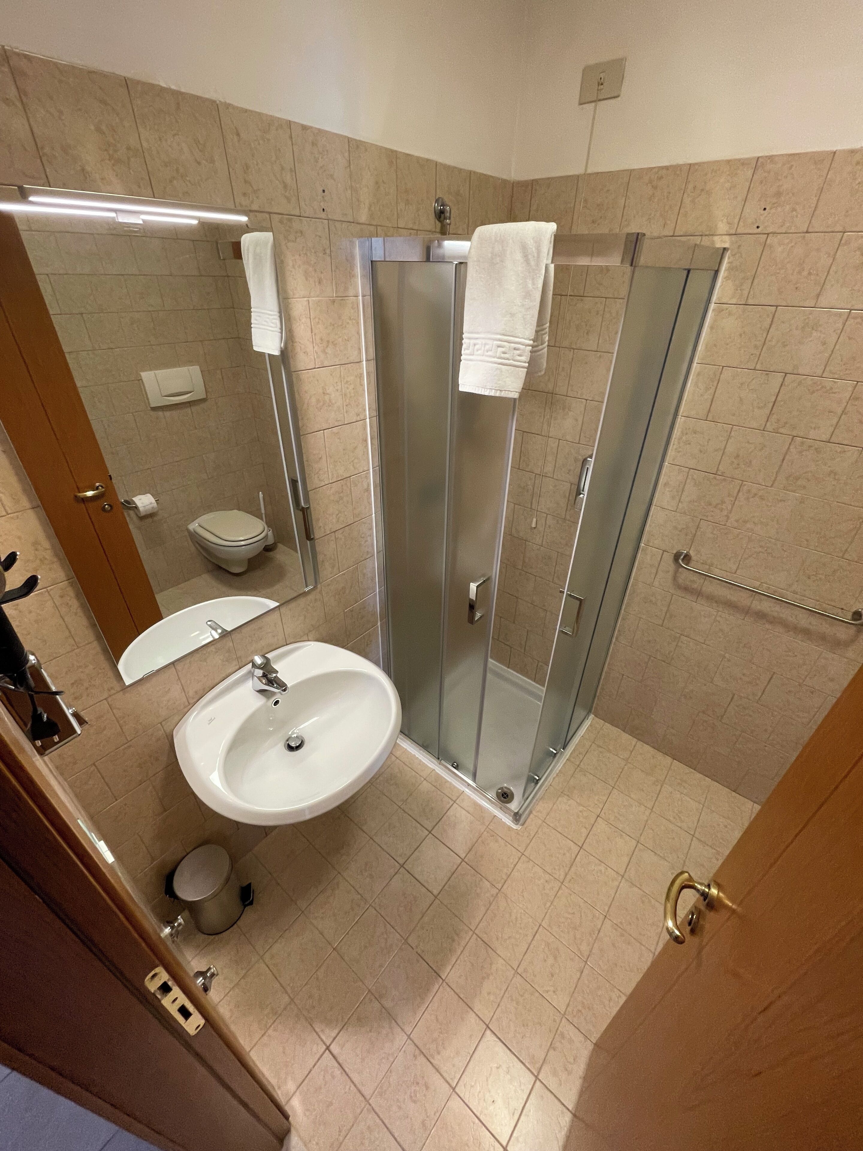 Une salle de bain avec une douche à parois de verre, un lavabo et des toilettes.