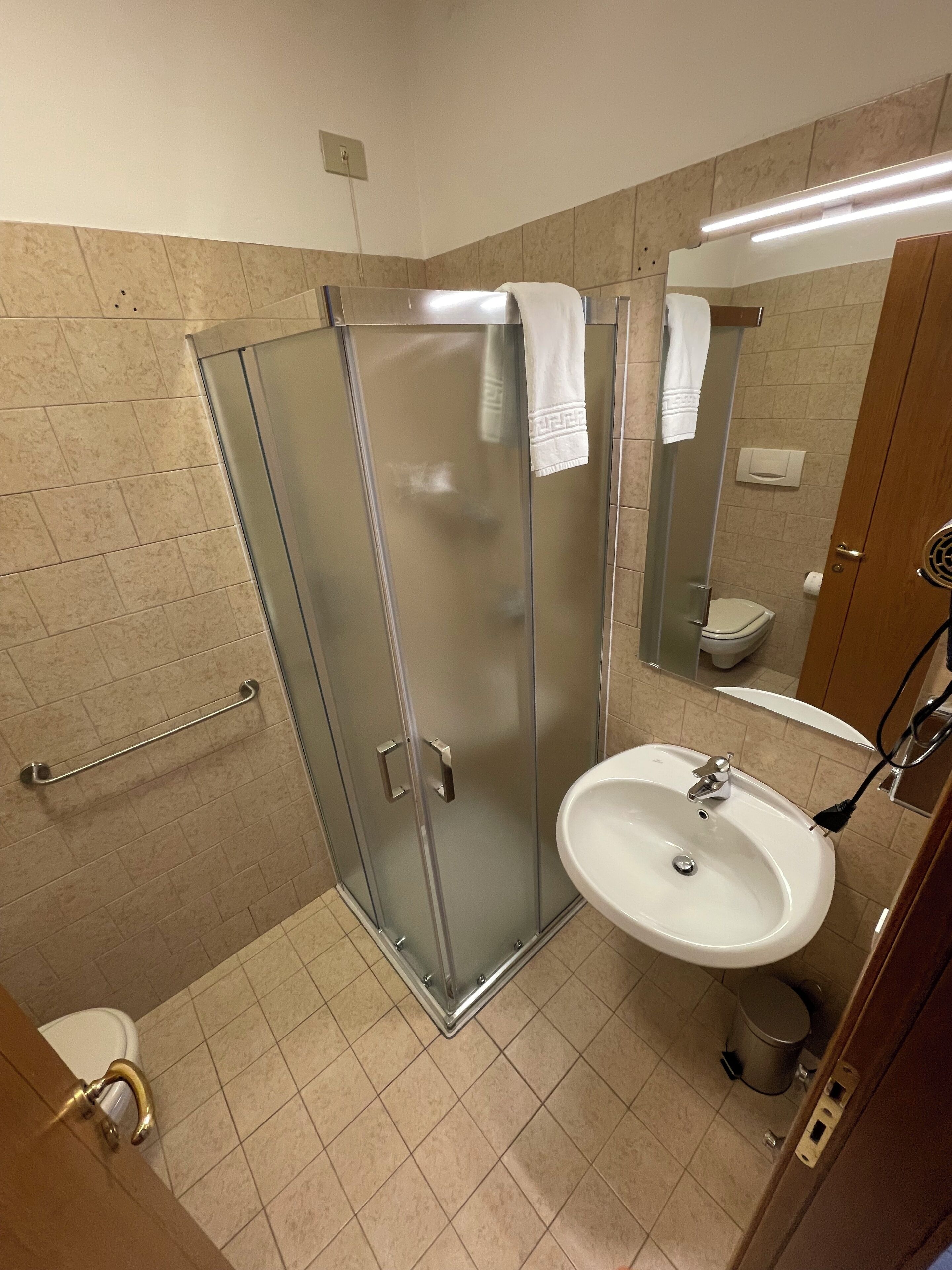 Ein modernes Badezimmer mit Duschkabine aus Glas, Waschbecken und Toilette.