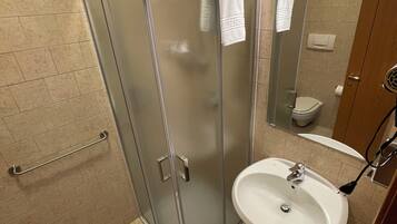 Ein modernes Badezimmer mit Duschkabine aus Glas, Waschbecken und Toilette.