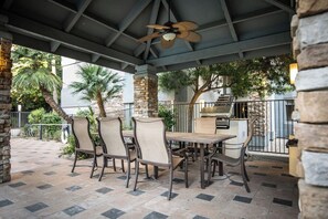 An outdoor patio with a covered seating area, stone pillars, and a grill. - Resort Style Biltmore Condo (Phoenix)