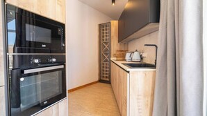 A compact kitchen with a built-in oven, a microwave, and a sink.