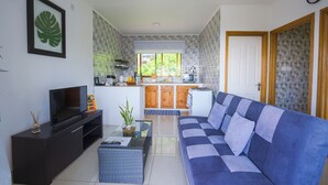 Un salon moderne avec un canapé, un téléviseur et une petite table basse.