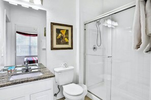 A bathroom with a sink, toilet, and shower.