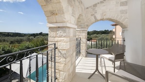 A balcony with stone arches, a pool, and outdoor furniture. - Villa Mason with Heated Pool and mini Wellness (Rovinjsko Selo)