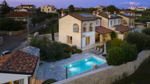 A residential area with stone buildings, a swimming pool, and a street. - Villa Mason with Heated Pool and mini Wellness (Rovinjsko Selo)