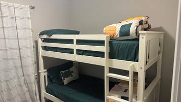 Un lit superposé à deux niveaux, chaque niveau étant équipé d’un matelas et d’oreillers.