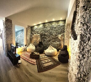 Um quarto acolhedor com parede de pedra, lareira e assentos confortáveis.
