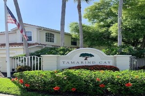 En lukket indgang med et skilt, der viser "Tamarind Cay", og et flagstang med et amerikansk flag.
