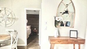 A room with a wooden table, a white chair, a wall-mounted mirror, and a decorative compass. - Clean, Bright & Peaceful home in quiet neighborhood close proximity to FSU &FAMU (Tallahassee)