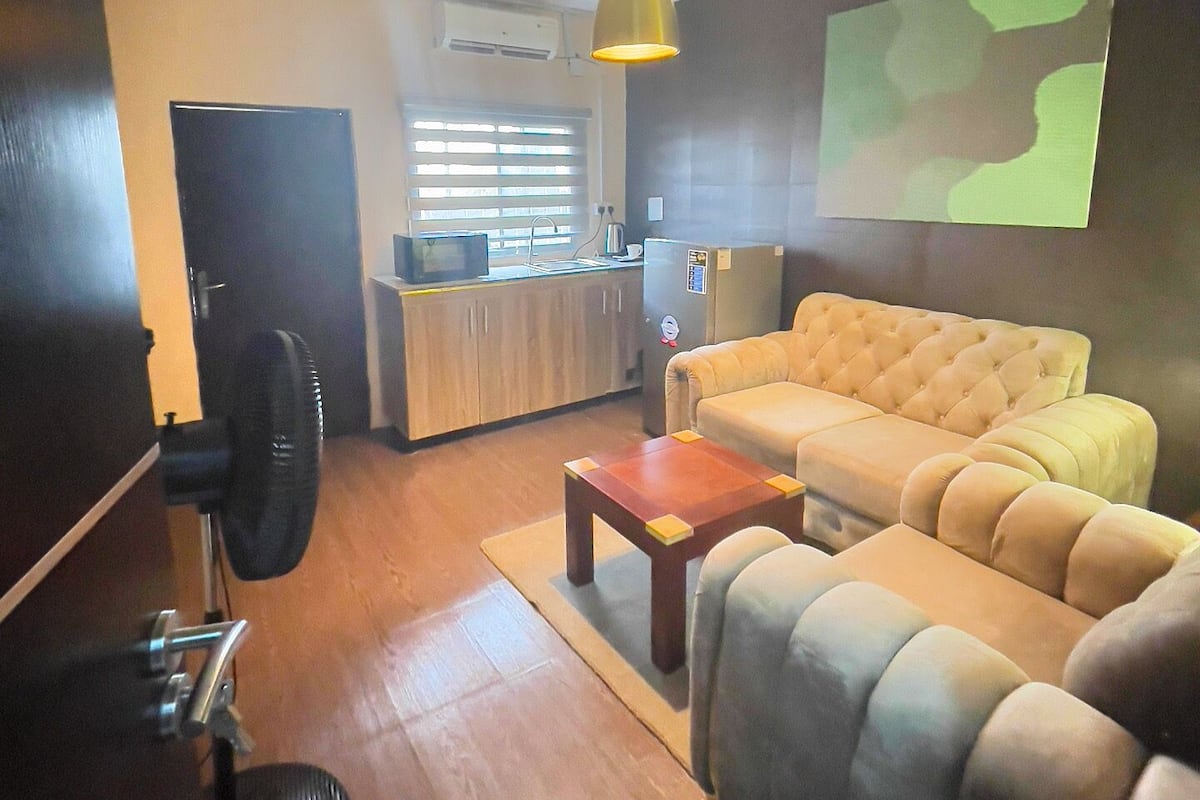 A modern living room with a sofa, a coffee table, and a projector screen.