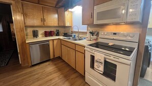 Una cocina con armarios de madera, electrodomésticos de acero inoxidable y un lavamanos de acero inoxidable.