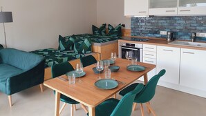 A modern kitchen with white cabinets, a built-in oven, and a coffee maker. - Oderbruch26 Your vacation home with sauna option (Letschin)