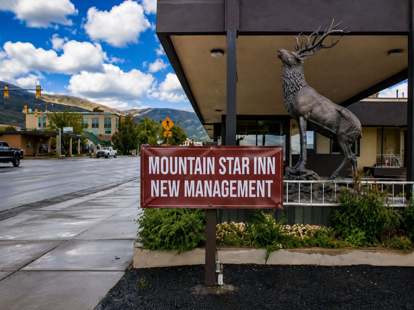 A sign for Mountain Star Inn with a deer statue.