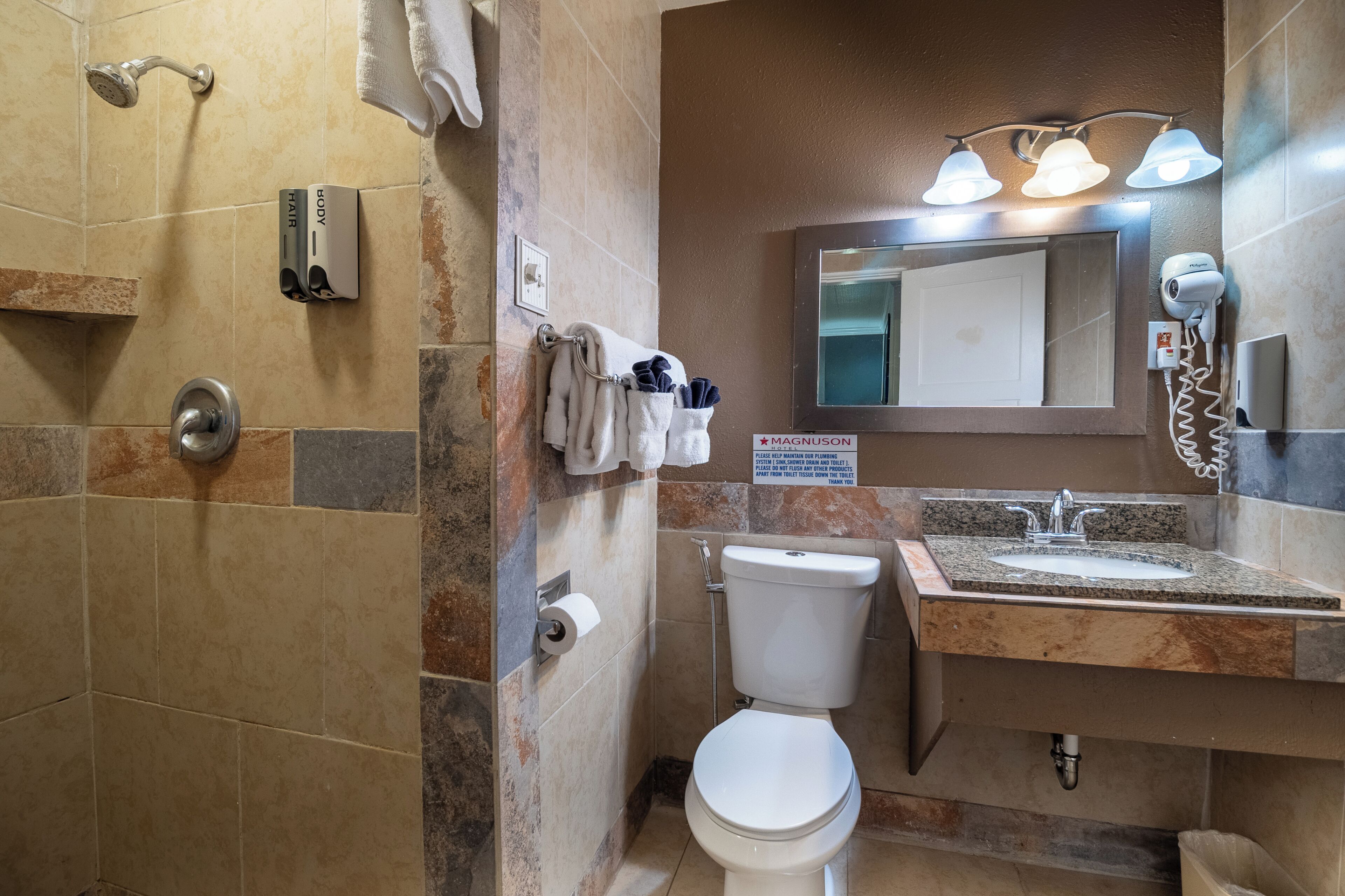 Ein Badezimmer mit Dusche, Toilette, Waschbecken und Handtuchhalter.