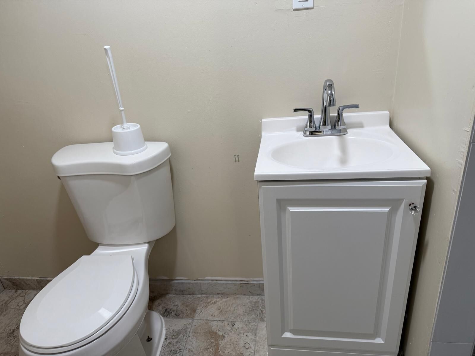 Un baño con inodoro, lavamanos y armario.