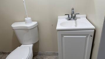 Un baño con inodoro, lavamanos y armario.
