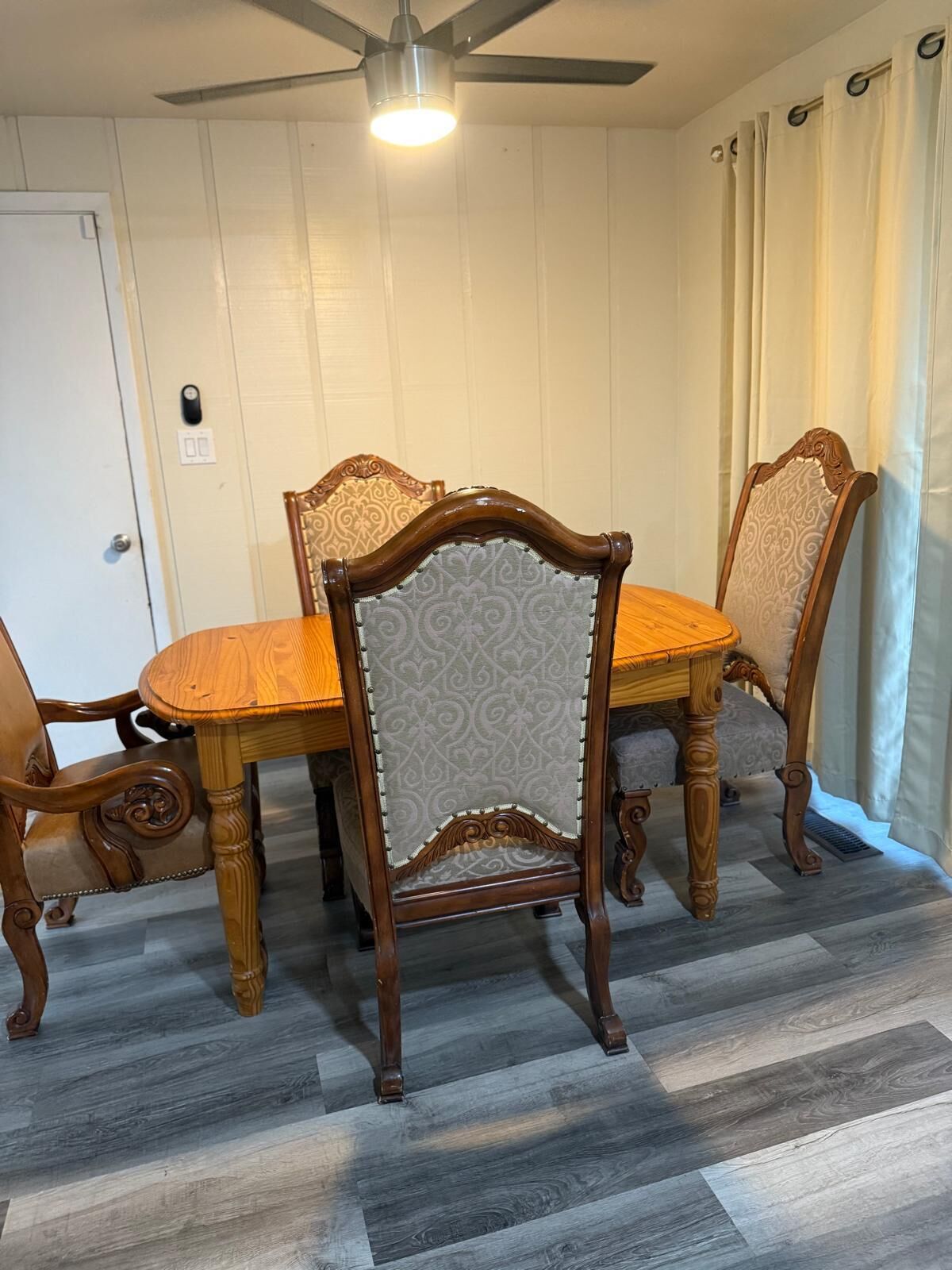 Ein Essbereich mit Holztisch und Stühlen, Deckenventilator und einer Lampe.
