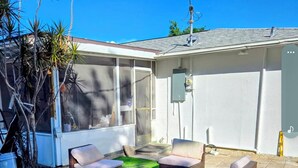 Une terrasse avec des meubles d’extérieur et une pelouse artificielle.