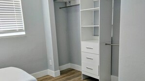 Une chambre à coucher avec un lit, une armoire et une fenêtre.