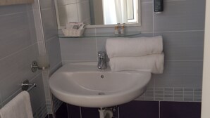 Een haardroger, handdoeken, zeep, toiletpapier