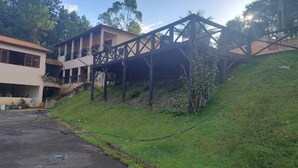 A building with a sloped roof and a covered walkway. - FARM WITH 7 CHALETS PERFECT FOR THAT FAMILY MOMENT (Santa Isabel)