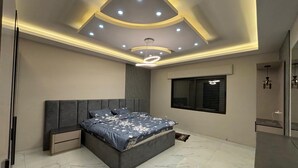 A modern bedroom with a large bed, recessed ceiling lighting, a window, and a built-in wardrobe. - 3-bedroom apartment in lovely Amman with AC (Amman)