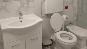 A bathroom with a marble backsplash, a sink, a toilet, and a bidet. - B&B Cavallotti (Mestre)