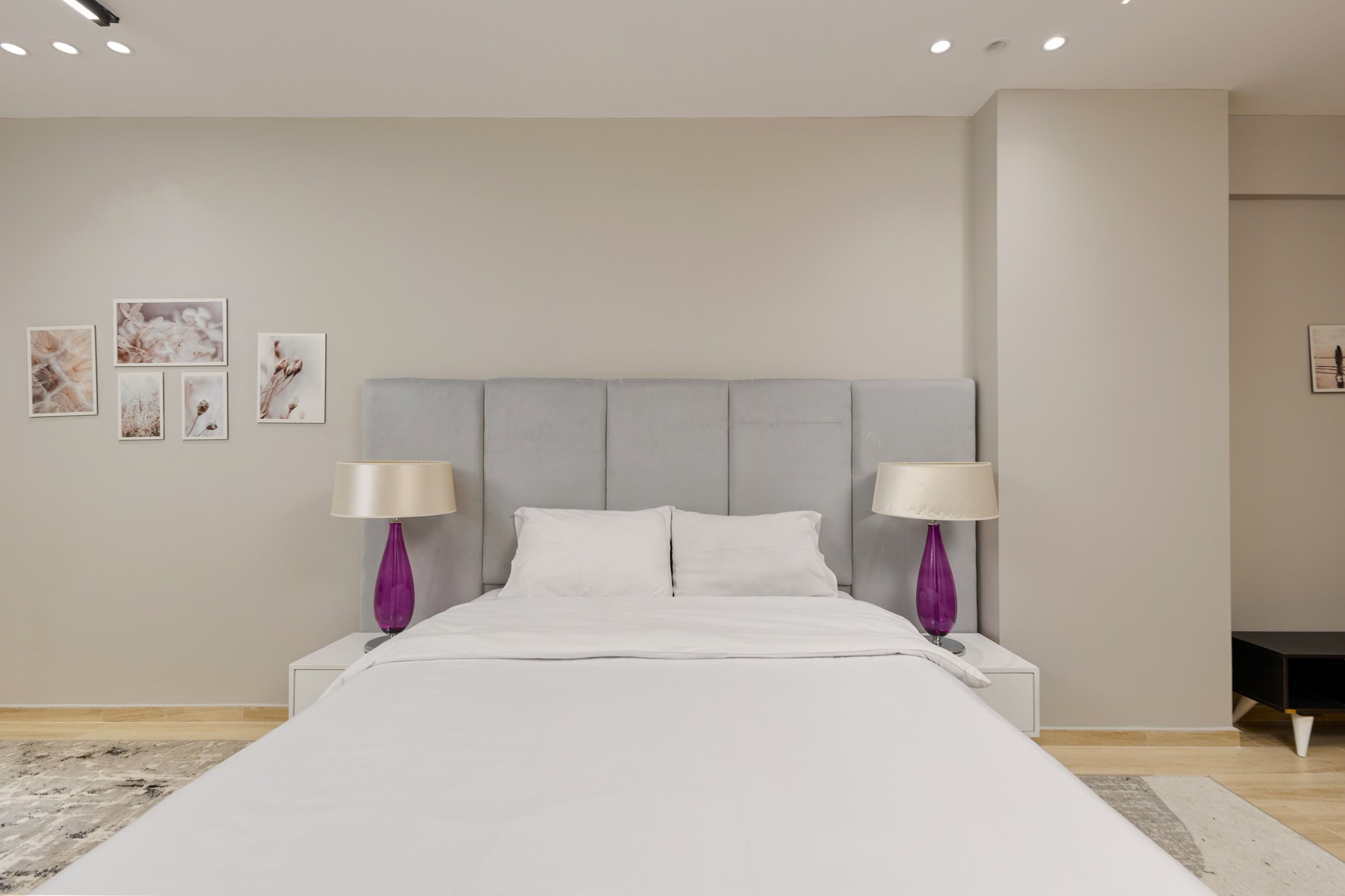 A modern bedroom with a large bed, two bedside tables, and a headboard.