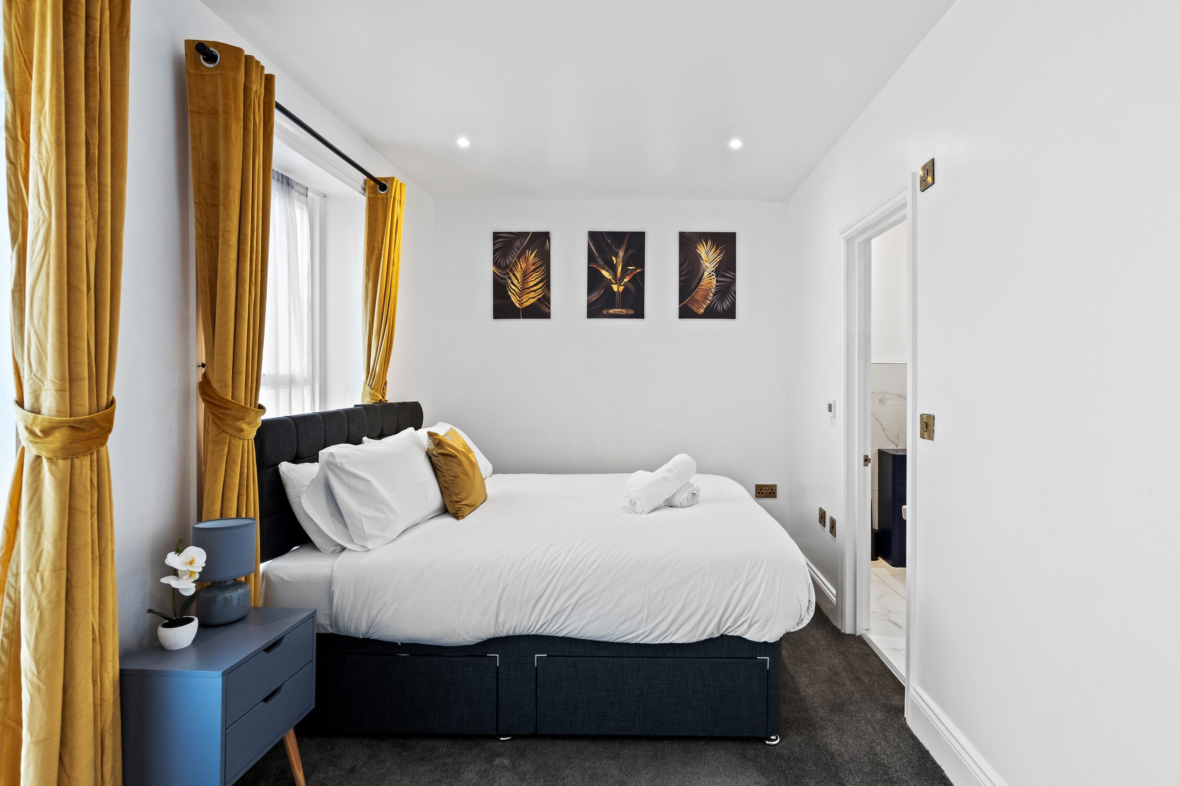 Ein modernes Schlafzimmer mit Bett, Nachttisch und einem Kunstwerk an der Wand.