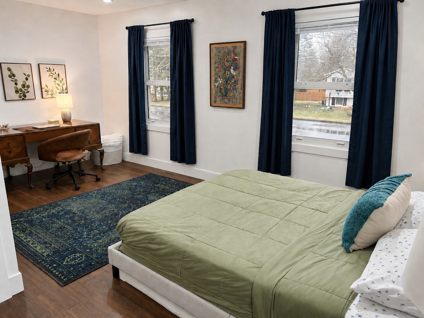 Ein Schlafzimmer mit einem Bett, einem Schreibtisch und zwei Fenstern mit Vorhängen.