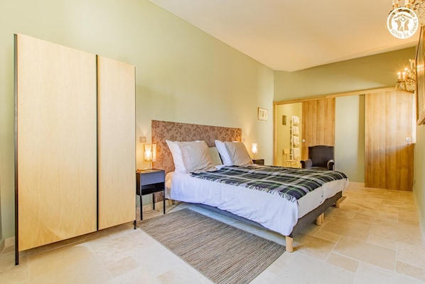 A bedroom with a bed, nightstands, a chair, and a wardrobe. - La Maison sur la Place (MAZILLE)