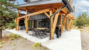 Une maison moderne dotée d’une terrasse en bois, d’un espace salon extérieur et d’une cuve à gaz.