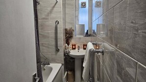 Ein modernes Badezimmer mit Badewanne, Waschbecken und Spiegel.