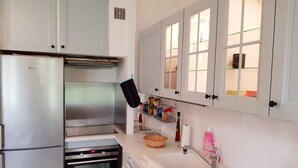 A kitchen with stainless steel appliances, a washing machine, and a sink with a drying rack. - Superb studio 2 to 4 people, seaside, casino and town center (Deauville)