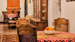 A dining area with wooden furniture, a cabinet with glass doors, and a painting on the wall.