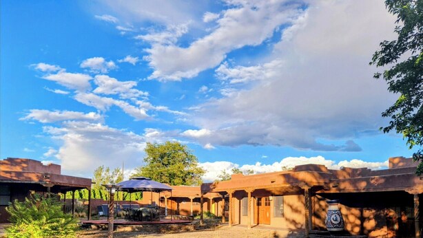 A courtyard with a pool, outdoor seating, and traditional architecture.