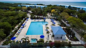 A resort with a large swimming pool, sun loungers, and a view of the ocean. - Updated Key Largo Condo at Ocean Pointe - Private Beach & Balcony Views (Key Largo)