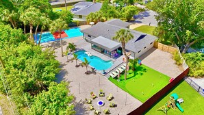 Una propiedad residencial con piscina, terraza cubierta y césped bien cuidado.