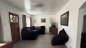 A modern living room with a sectional sofa, a bean bag chair, a TV, and a fireplace. - 3-bedroom bungalow, centrally located in charming Saint Joseph (Saint Joseph)