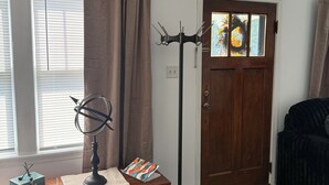 A room with a wooden dresser, a globe, and a coat rack. - 3-bedroom bungalow, centrally located in charming Saint Joseph (Saint Joseph)