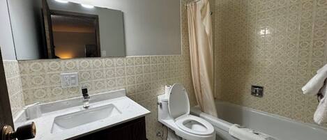 Ein Badezimmer mit Waschbecken, Toilette und Badewanne.