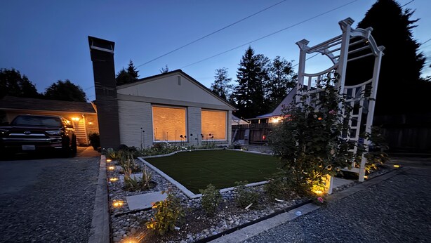 Une propriété résidentielle dotée d’une pelouse bien entretenue, d’une allée et d’un garage.