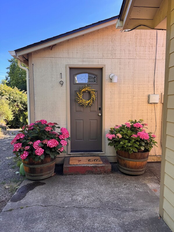 A house with a brown door, number 19, a wreath, and two large flower pots with pink flowers. - Charming 2-bedroom bungalow in welcoming Burien (Burien)