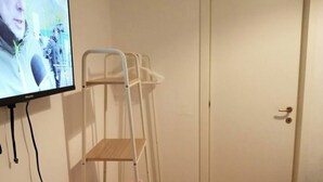 Ett rum med en våningssäng, en tv som är monterad på väggen och en dörr.