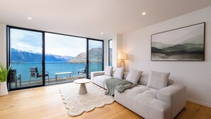 Un salon moderne doté d’une grande fenêtre offrant une vue imprenable sur les montagnes.