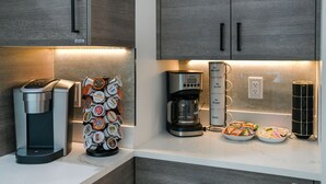 A modern kitchen with a coffee machine, a coffee maker, and a coffee pod holder. - Staycation Station (Tampa)